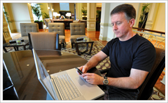 Hotel customer sitting using a computer accessing the internet from hotel wireless connection